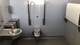Toiletbygning til vejdirektoratet ved Isterød Øst og Vest - inventar i rustfrit stål, toilet, puslebord, håndvask og skraldespande.