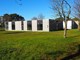 Flexicubes® moduler til Viborg Kommune første bygning. Den grå facade med træbeklædning over vinduerne. Bygningen står på et stort græsområde